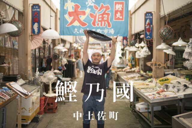 かつおを持ち上げる鮮魚店の店長